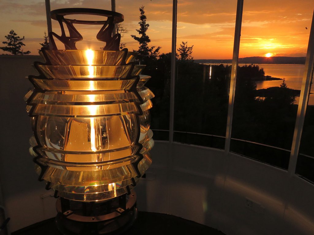 Sunset behind the 4th Order Fresnel lens inside Owls Head Lighthouse